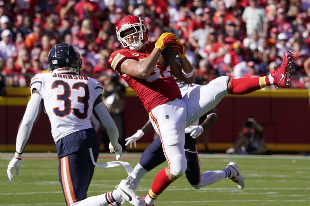 Kansas City Chiefs tight end Travis Kelce catches a pass as Chicago Bears cornerback Jaylon Johnson (33) defends during the first half of an NFL football game Sunday, Sept. 24, 2023, in Kansas City, Mo. (AP Photo/Ed Zurga)