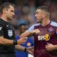 Referee Jarred Gillett, left, discusses with Aston Villa's John McGinn during the English Premier League soccer match between Chelsea and Aston Villa at Stamford Bridge stadium in London, Sunday, Sept. 24, 2023. (AP Photo/Alastair Grant)