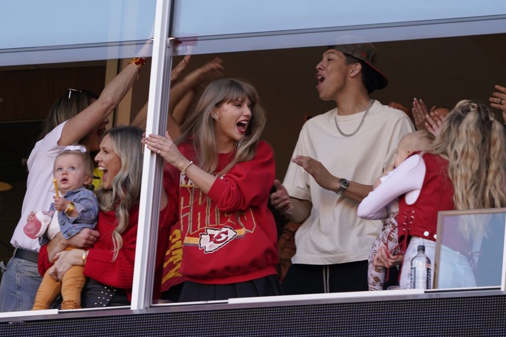 Taylor Swift celebrates as she watches from a suit during the first half of an NFL football game between the Kansas City Chiefs and the Los Angeles Chargers Sunday, Oct. 22, 2023, in Kansas City, Mo. (AP Photo/Ed Zurga)