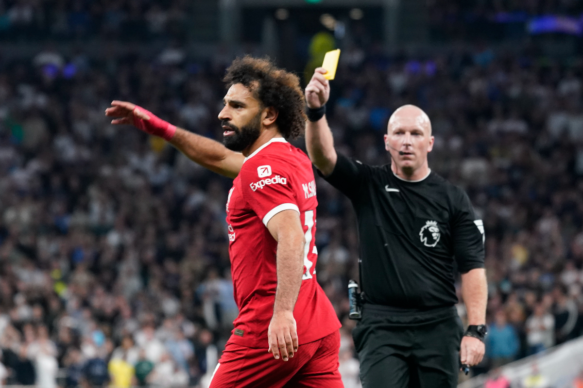 Referee Simon Hooper shows the yellow card to Liverpool's Mohamed Salah during the English Premier League soccer match between Tottenham Hotspur and Liverpool at the Tottenham Hotspur Stadium, in London, England, Saturday, Sept. 30, 2023. (AP Photo/Alberto Pezzali)