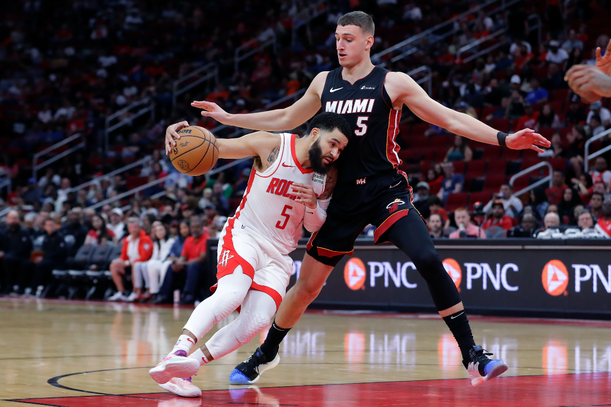 Houston Rockets guard Fred VanVleet, left, drives under Miami Heat forward Nikola Jovic, right, during the second half of a preseason NBA basketball game Friday, Oct. 20, 2023, in Houston. (AP Photo/Michael Wyke)