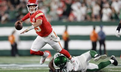 Kansas City Chiefs quarterback Patrick Mahomes (15) is tripped up by New York Jets linebacker Bryce Huff (47) as he throws during the second quarter of an NFL football game, Sunday, Oct. 1, 2023, in East Rutherford, N.J. (AP Photo/Adam Hunger)