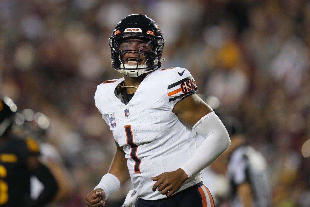 Chicago Bears quarterback Justin Fields (1) reacting after throwing a touchdown pass to wide receiver DJ Moore during the first half of an NFL football game against the Washington Commanders, Thursday, Oct. 5, 2023, in Landover, Md. (AP Photo/Alex Brandon)