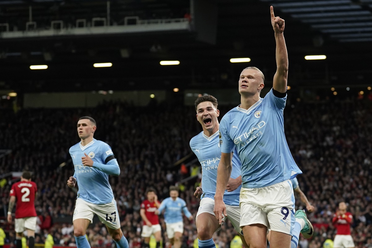 Manchester City's Erling Haaland, right, celebrates after scoring his side's opening goal from a penalty kick during the English Premier League soccer match between Manchester United and Manchester City at Old Trafford stadium in Manchester, England, Sunday, Oct. 29, 2023. (AP Photo/Dave Thompson)
