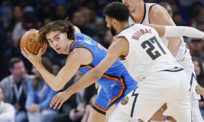 Oklahoma City Thunder guard Josh Giddey, left, holds the ball away from Denver Nuggets guard Jamal Murray (27) and center Nikola Jokic, right, in the first half of an NBA basketball game, Sunday, Oct. 29, 2023, in Oklahoma City. (AP Photo/Nate Billings)