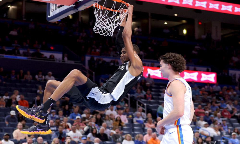 San Antonio Spurs center Victor Wembanyama, left, dunks next to Oklahoma City Thunder guard Josh Giddey, right, in the first half of a preseason NBA basketball game Monday, Oct. 9, 2023, in Oklahoma City. (AP Photo/Sarah Phipps)