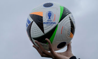 A woman shows the UEFA Euro 2024 Ball during a presentation in Berlin, Germany, Wednesday, Nov. 15, 2023. The ball is named 'Fussballliebe' - 'Footbal Love' or 'Soccer Love'. (AP Photo/Markus Schreiber)