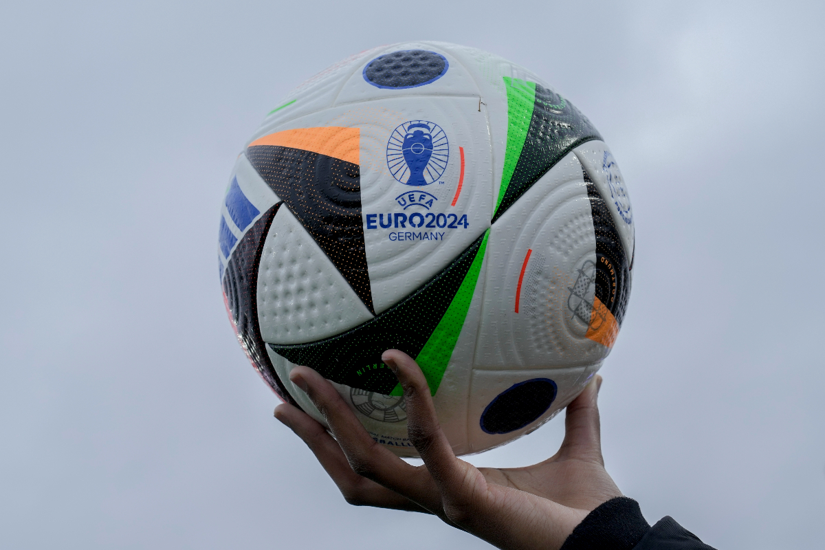 A woman shows the UEFA Euro 2024 Ball during a presentation in Berlin, Germany, Wednesday, Nov. 15, 2023. The ball is named 'Fussballliebe' - 'Footbal Love' or 'Soccer Love'. (AP Photo/Markus Schreiber)