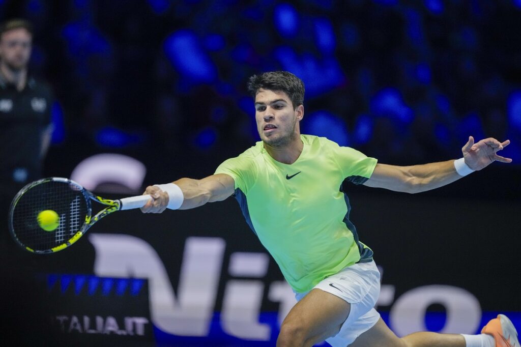 Spain's Carlos Alcaraz plays a forehand return to to Serbia's Novak Djokovic during their singles semifinal tennis match of the ATP World Tour Finals at the Pala Alpitour, in Turin, Italy, Saturday, Nov. 18, 2023. (AP Photo/Antonio Calanni)