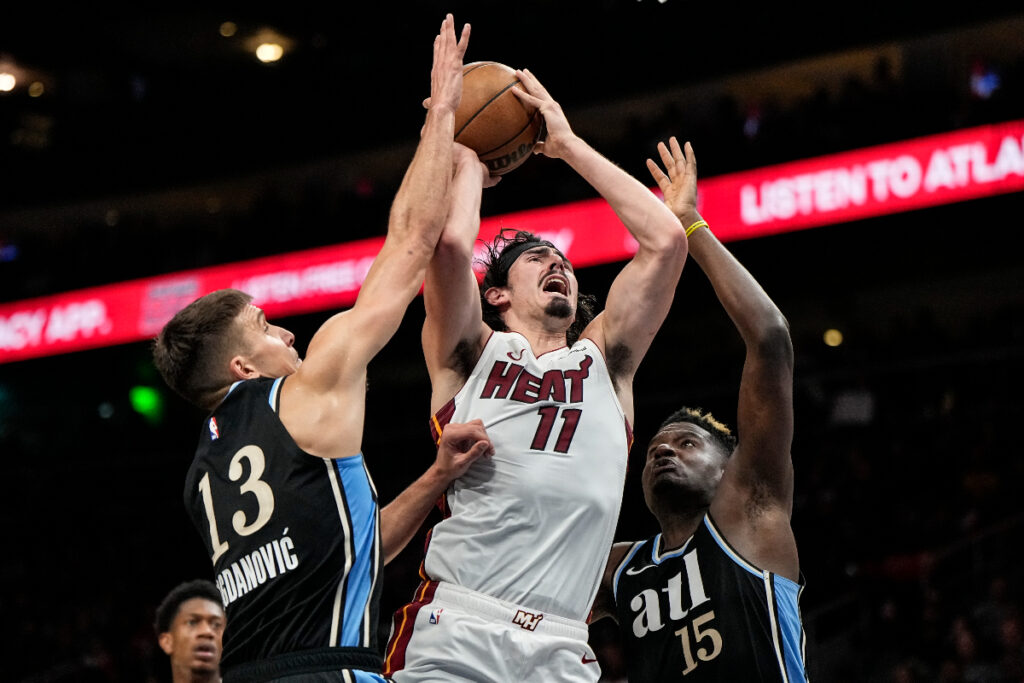 Miami Heat guard Jaime Jaquez Jr. (11) shoots against Atlanta Hawks guard Bogdan Bogdanovic (13) and center Clint Capela (15) during the second half of an NBA basketball game, Saturday, Nov. 11, 2023, in Atlanta. The Miami Heat won 117-109. (AP Photo/Mike Stewart)