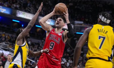 Chicago Bulls center Nikola Vucevic (9) shoots between Indiana Pacers forward Aaron Nesmith (23) and guard Buddy Hield (7) during the second half of an NBA basketball game in Indianapolis, Monday, Oct. 30, 2023. The Bulls defeated the Pacers 112-105. (AP Photo/Michael Conroy)