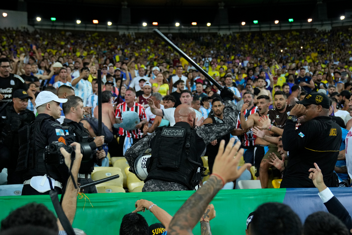 Policemen try to stop a fight between Brazilian and Argentinians fans at the stands prior to a qualifying soccer match for the FIFA World Cup 2026 at Maracana stadium in Rio de Janeiro, Brazil, Tuesday, Nov. 21, 2023.(AP Photo/Silvia Izquierdo)