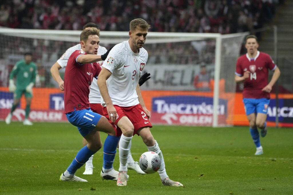 Czech Republic's Jan Kuchta, left, challenges Poland's Pawel Bochniewicz during the Euro 2024 group E qualifying soccer match between Poland and Czech Republic at the National stadium in Warsaw, Poland, Friday, Nov. 17, 2023. (AP Photo/Czarek Sokolowski)