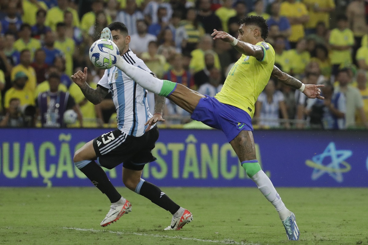 Brazil's Raphinha stretches for a ball challenged by Argentina's Cristian Romero during a qualifying soccer match for the FIFA World Cup 2026 at Maracana stadium in Rio de Janeiro, Brazil, Tuesday, Nov. 21, 2023. (AP Photo/Bruna Prado)