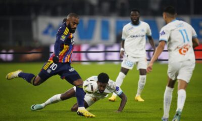 Lyon's Alexandre Lacazette, left, and Marseille's Michael Murillo, centre, challenge for the ball during the French League One soccer match between Olympique de Marseille and Lyon at the Velodrome Stadium in Marseille, France, Wednesday, Dec. 6, 2023. (AP Photo/Daniel Cole)