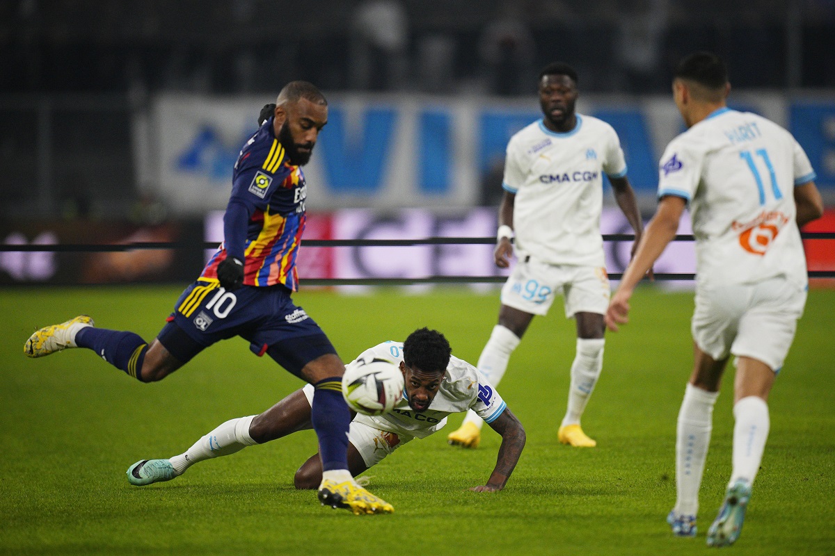 Lyon's Alexandre Lacazette, left, and Marseille's Michael Murillo, centre, challenge for the ball during the French League One soccer match between Olympique de Marseille and Lyon at the Velodrome Stadium in Marseille, France, Wednesday, Dec. 6, 2023. (AP Photo/Daniel Cole)
