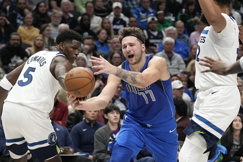 Dallas Mavericks guard Luka Doncic (77) is fouled by Minnesota Timberwolves guard Anthony Edwards (5) during the first half of an NBA basketball game in Dallas, Thursday, Dec. 14, 2023. (AP Photo/LM Otero)