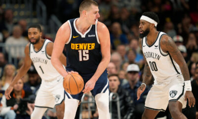 Denver Nuggets center Nikola Jokic, left, is defended by Brooklyn Nets forward Royce O'Neale during the second half of an NBA basketball game Thursday, Dec. 14, 2023, in Denver. (AP Photo/David Zalubowski)