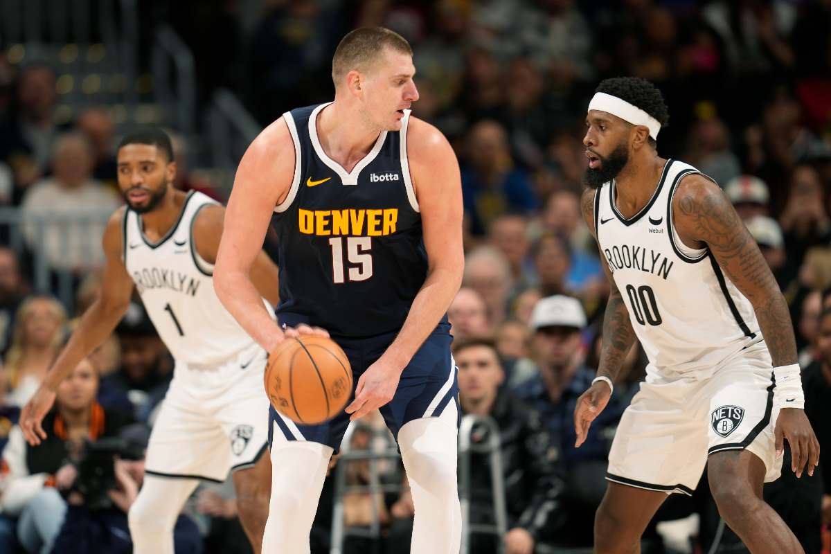 Denver Nuggets center Nikola Jokic, left, is defended by Brooklyn Nets forward Royce O'Neale during the second half of an NBA basketball game Thursday, Dec. 14, 2023, in Denver. (AP Photo/David Zalubowski)