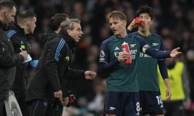 Arsenal's Martin Odegaard, second right, speaks to members of team support staff during the English Premier League soccer match between Arsenal and Fulham at Craven Cottage stadium in London, Sunday, Dec. 31, 2023. (AP Photo/Alastair Grant)