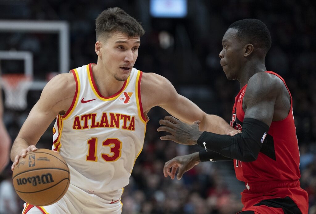 Atlanta Hawks Bogdan Bogdanović (13) drives past Toronto Raptors guard Dennis Schröder during the second half of an NBA basketball game in Toronto, Wednesday, Dec. 13, 2023. (Frank Gunn/The Canadian Press via AP)