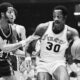 FILE - Golden State Warriors Jamaal Wilkes (41) tries to keep 76ers forward George McGinnis (30) from getting closer to the basket during the first half of NBA game on Tuesday, Nov. 25, 1975 in Philadelphia. McGinnis, a Hall of Fame forward who was a two-time ABA champion and three-time All-Star in the NBA and ABA, died Thursday, Dec. 14, 2023 He was 73. (AP Photo/Rusty Kennedy, File)