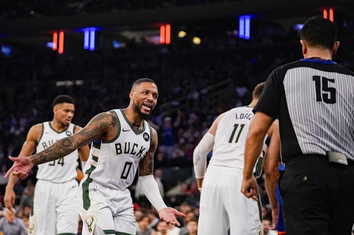 Milwaukee Bucks guard Damian Lillard (0) argues a call with referee Zach Zarba (15) during the first half of an NBA basketball game against the New York Knicks in New York, Saturday, Dec. 23, 2023. (AP Photo/Peter K. Afriyie)