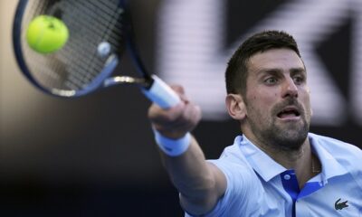 Novak Djokovic of Serbia plays a forehand return to Taylor Fritz of the U.S. during their quarterfinal match at the Australian Open tennis championships at Melbourne Park, Melbourne, Australia, Tuesday, Jan. 23, 2024. (AP Photo/Andy Wong)