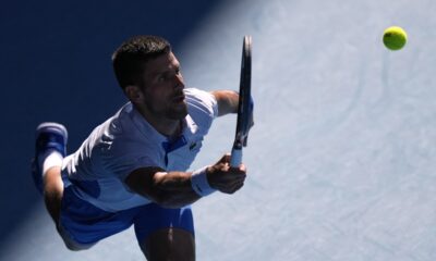 Novak Djokovic of Serbia plays a forehand return to Taylor Fritz of the U.S. during their quarterfinal match at the Australian Open tennis championships at Melbourne Park, Melbourne, Australia, Tuesday, Jan. 23, 2024. (AP Photo/Louise Delmotte)