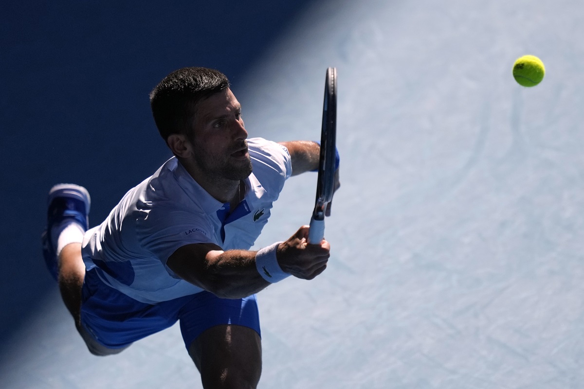 Novak Djokovic of Serbia plays a forehand return to Taylor Fritz of the U.S. during their quarterfinal match at the Australian Open tennis championships at Melbourne Park, Melbourne, Australia, Tuesday, Jan. 23, 2024. (AP Photo/Louise Delmotte)