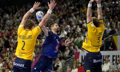Sweden's Max Darj and Sweden's Jonathan Carlsbogard fail to prevent France's Nikola Karabatic from scoring during the Handball European Championship semifinal match between France and Sweden in Cologne, Germany, Friday, Jan. 26, 2024. (AP Photo/Martin Meissner)
