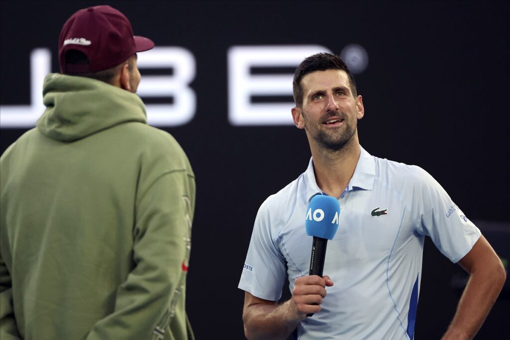 Novak Djokovic, right, of Serbia is interviewed by Nick Kyrgios following his win over Taylor Fritz of the U.S. in their quarterfinal match at the Australian Open tennis championships at Melbourne Park, Melbourne, Australia, Tuesday, Jan. 23, 2024. (AP Photo/Asanka Brendon Ratnayake)
