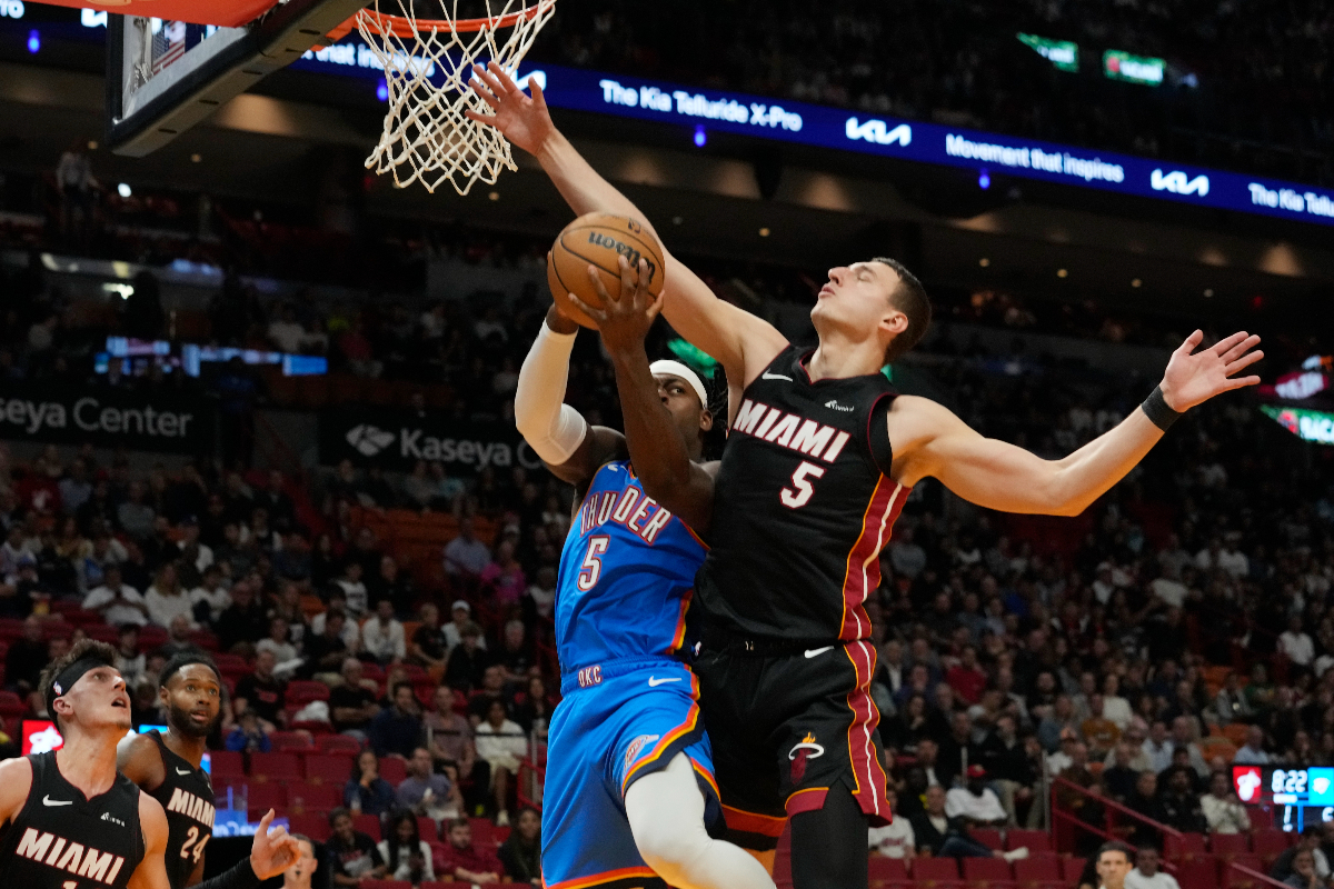 Oklahoma City Thunder guard Luguentz Dort (5) drives to the basket as Miami Heat forward Nikola Jovic (5) defends during the first half of an NBA basketball game, Wednesday, Jan. 10, 2024, in Miami. (AP Photo/Marta Lavandier