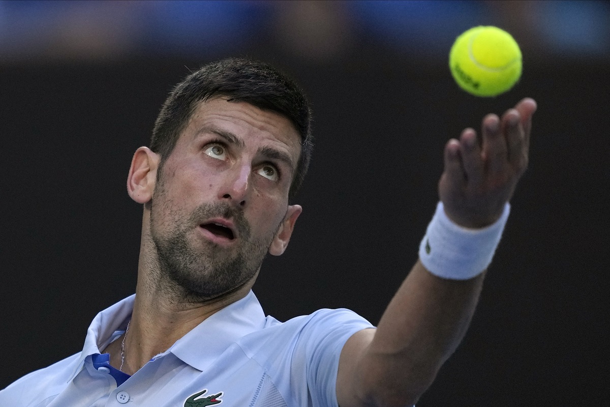 Novak Djokovic of Serbia serves to Taylor Fritz of the U.S. during their quarterfinal match at the Australian Open tennis championships at Melbourne Park, Melbourne, Australia, Tuesday, Jan. 23, 2024. (AP Photo/Louise Delmotte)