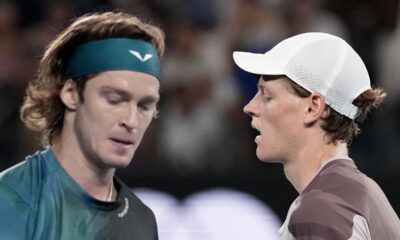 Jannik Sinner, right, of Italy and Andrey Rublev of Russia cross at a change of ends during their quarterfinal match at the Australian Open tennis championships at Melbourne Park, Melbourne, Australia, Wednesday, Jan. 24, 2024. (AP Photo/Alessandra Tarantino)