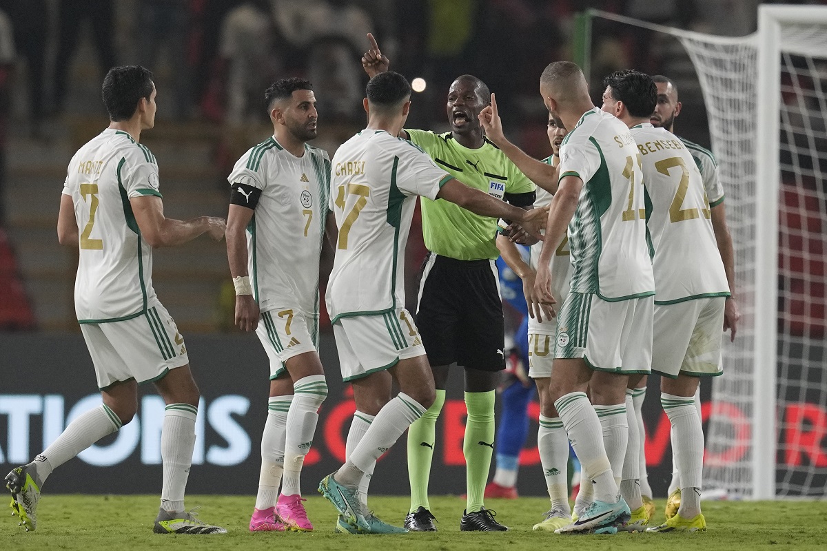 Algeria players protest to the referee Issa Sy during the African Cup of Nations Group D soccer match between Algeria and Angola in Bouake, Ivory Coast, Monday, Jan. 15, 2024. (AP Photo/Themba Hadebe)