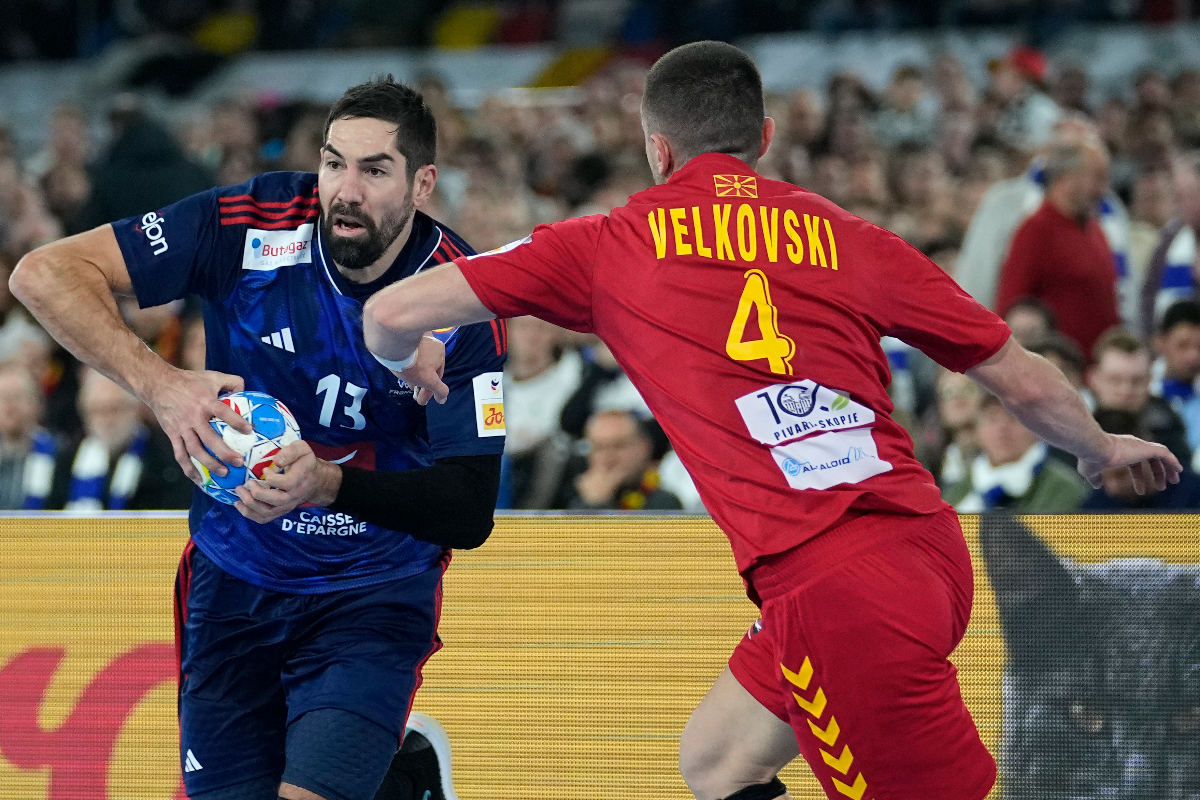 North Macedonia's Martin Velkovski, right, challenges France's Nikola Karabatic during the Men's European Handball Championship match between France and North Macedonia at the soccer stadium in Duesseldorf, Germany, Wednesday, Jan. 10, 2024. (AP Photo/Martin Meissner)