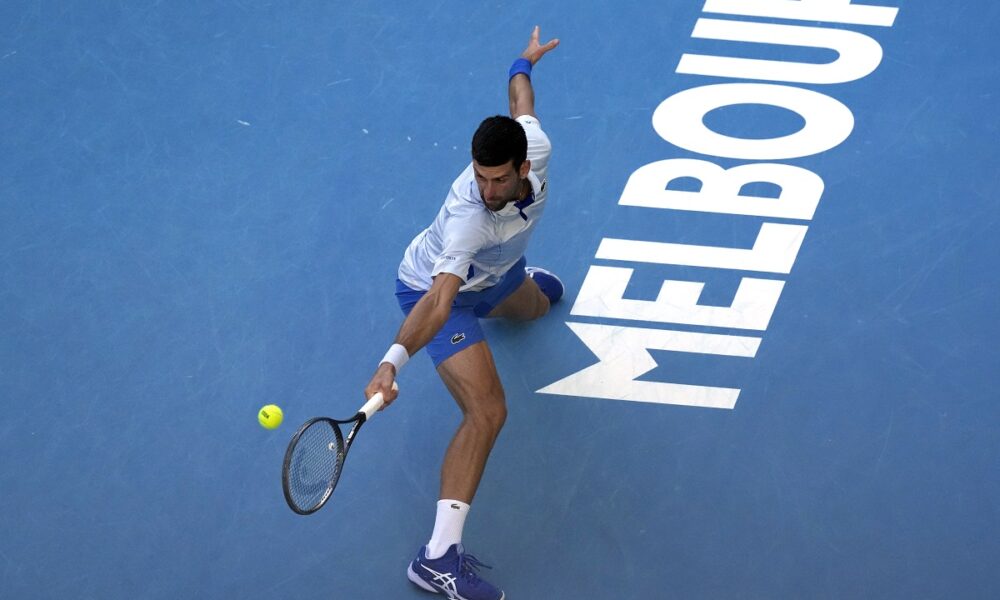 Novak Djokovic of Serbia plays a backhand return to Taylor Fritz of the U.S. during their quarterfinal match at the Australian Open tennis championships at Melbourne Park, Melbourne, Australia, Tuesday, Jan. 23, 2024. (AP Photo/Alessandra Tarantino)