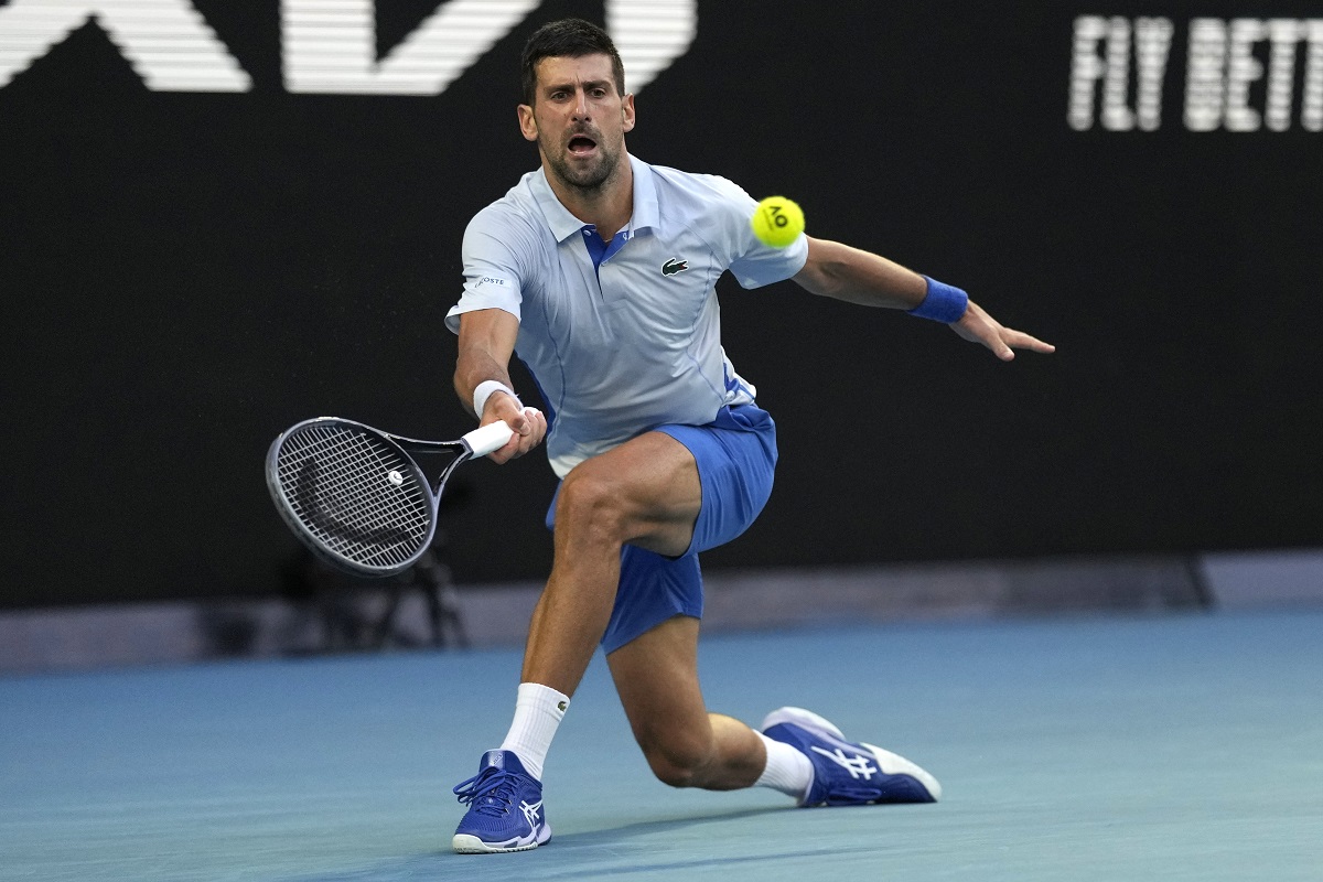 Novak Djokovic of Serbia plays a forehand return to Taylor Fritz of the U.S. during their quarterfinal match at the Australian Open tennis championships at Melbourne Park, Melbourne, Australia, Tuesday, Jan. 23, 2024. (AP Photo/Louise Delmotte)