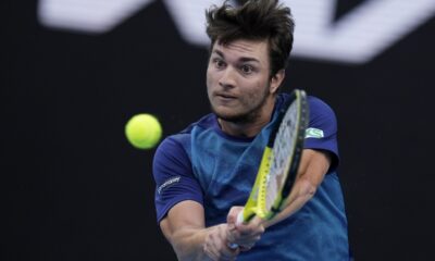 Miomir Kecmanovic of Serbia plays a backhand return to Carlos Alcaraz of Spain during their fourth round match at the Australian Open tennis championships at Melbourne Park, Melbourne, Australia, Monday, Jan. 22, 2024. (AP Photo/Andy Wong)