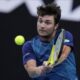 Miomir Kecmanovic of Serbia plays a backhand return to Carlos Alcaraz of Spain during their fourth round match at the Australian Open tennis championships at Melbourne Park, Melbourne, Australia, Monday, Jan. 22, 2024. (AP Photo/Andy Wong)