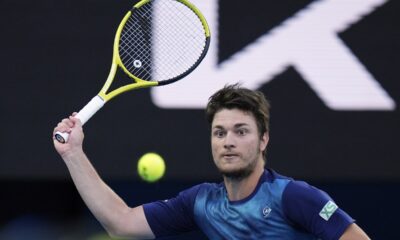 Miomir Kecmanovic of Serbia plays a forehand return to Carlos Alcaraz of Spain during their fourth round match at the Australian Open tennis championships at Melbourne Park, Melbourne, Australia, Monday, Jan. 22, 2024. (AP Photo/Andy Wong)