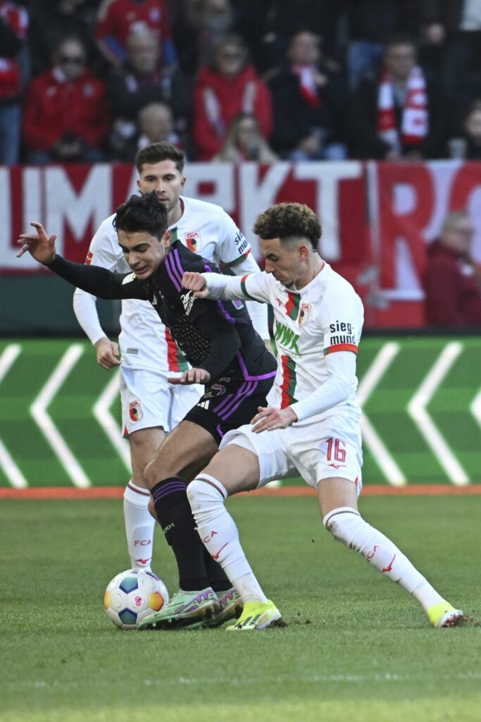 Augsburg's Ruben Vargas, right, and Munich's Aleksandar Pavlovic battle for the ball during the Bundesliga soccer match between FC Augsburg and Bayern Munich at the WWK-Arena, Augsburg, Germany, Saturday Jan. 27, 2024. (Sven Hoppe/dpa via AP)
