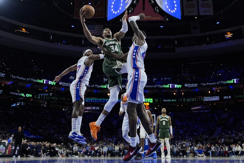 Milwaukee Bucks' Giannis Antetokounmpo (34) goes up for a shot against Philadelphia 76ers' Buddy Hield, left, and Paul Reed during the second half of an NBA basketball game, Sunday, Feb. 25, 2024, in Philadelphia. (AP Photo/Matt Rourke)