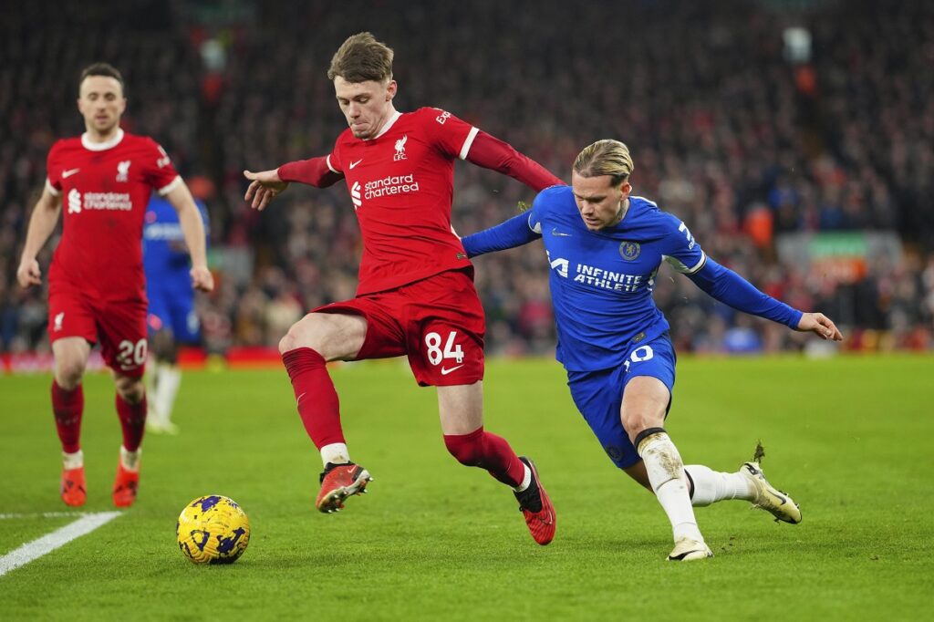 Liverpool's Conor Bradley, left, challenges for the ball with Chelsea's Mykhailo Mudryk during the English Premier League soccer match between Liverpool and Chelsea, at Anfield Stadium, Liverpool, England, Wednesday, Jan.31, 2024. (AP Photo/Jon Super)