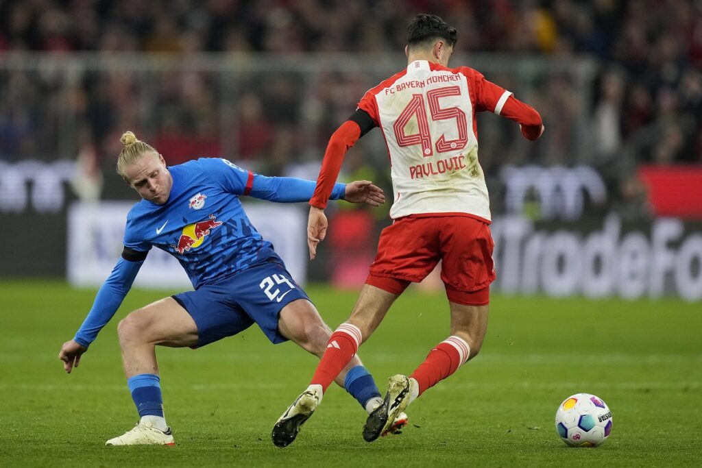 Leipzig's Xaver Schlager, left, and Bayern's Aleksandar Pavlovic challenge for the ball during the German Bundesliga soccer match between FC Bayern Munich and RB Leipzig at the Allianz Arena in Munich, Germany, Feb. 24, 2024. (AP Photo/Matthias Schrader)