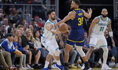 Charlotte Hornets guard Vasilije Micic, left, passes the ball while defended by Golden State Warriors guard Stephen Curry (30) during the first half of an NBA basketball game Friday, Feb. 23, 2024, in San Francisco. (AP Photo/Godofredo A. Vásquez)