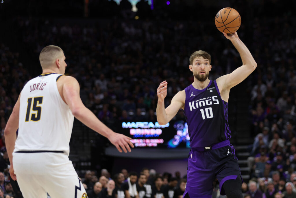 Sacramento Kings forward Domantas Sabonis (10) passes the ball as Denver Nuggets center Nikola Jokic (15) defends during the second half of an NBA basketball game in Sacramento, Calif, Friday, Feb. 9, 2024. (AP Photo/Jed Jacobsohn)