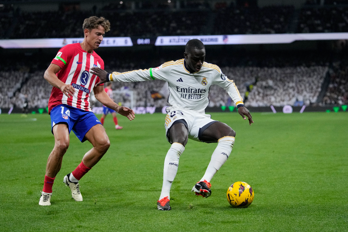Atletico Madrid's Marcos Llorente, left, and Real Madrid's Ferland Mendy challenge for the ball during the Spanish La Liga soccer match between Real Madrid and Atletico Madrid at the Santiago Bernabeu stadium in Madrid, Spain, Sunday, Feb. 4, 2024. (AP Photo/Bernat Armangue)