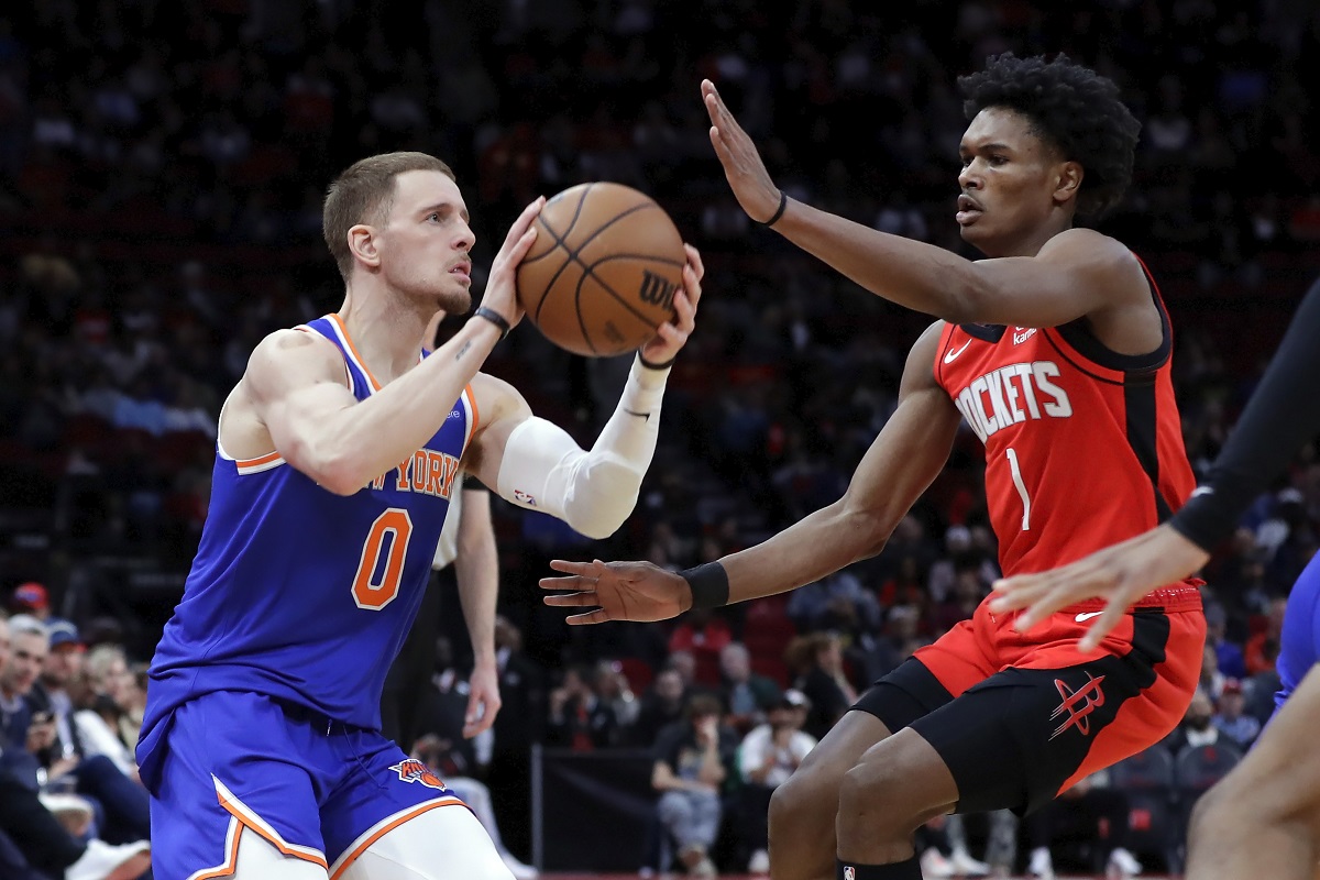 New York Knicks guard Donte DiVincenzo (0) looks to shoot while under pressure from Houston Rockets forward Amen Thompson (1) during the first half of an NBA basketball game Monday, Feb. 12, 2024, in Houston. (AP Photo/Michael Wyke)
